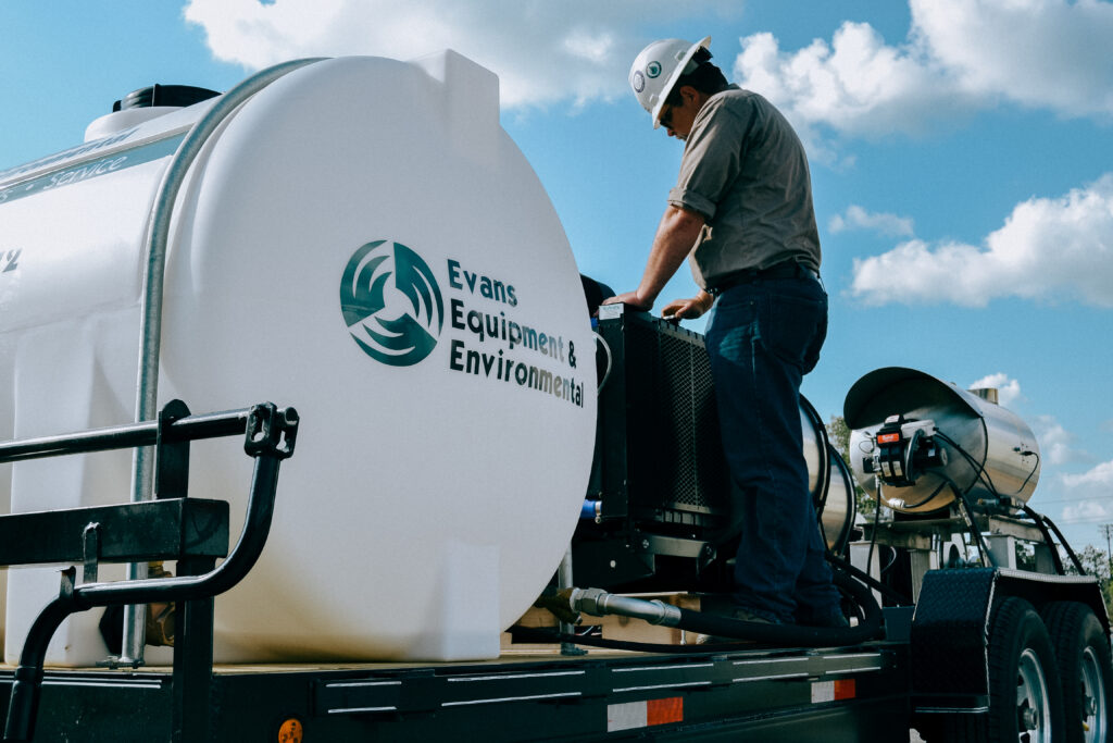 A technician from Evans Equipment & Environmental working on a portable heavy equipment cleaning system in the field